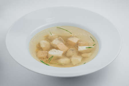 Soup with red and white fish in a white plateの写真素材