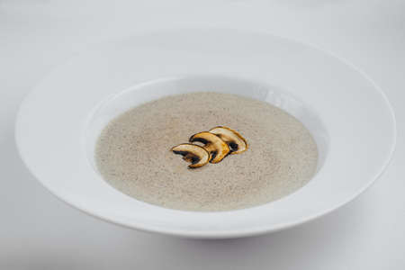 Mushroom cream soup in white plate on a white backgroundの写真素材