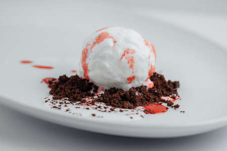 ice cream with strawberry syrup and chocolate chips closeup on a white bsckgroundの写真素材