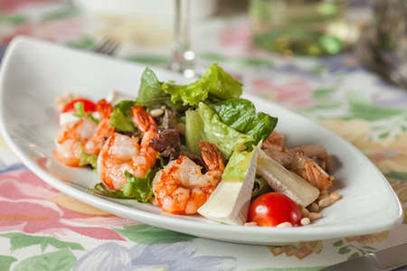 boiled shrimp with lettuce on a white plateの写真素材