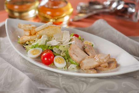 Delicious Caesar salad with chicken meat and cheese on a plateの写真素材