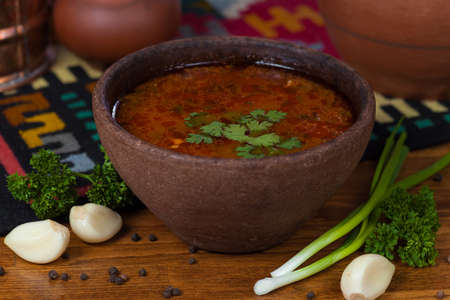 Delicious soup with herbs in a clay potの写真素材