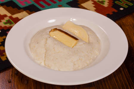 Garnish. Porridge with cheese and oil in a white plateの写真素材