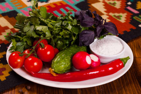 Composition of fresh vegetables and greens on a plateの写真素材