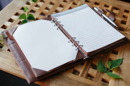 Open notepad with a ballpoint pen on the summer tableの写真素材