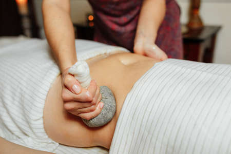 Massage of the stomach with herbal compressesの写真素材
