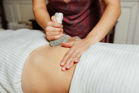 Thai massage with sachet. Massage of the abdominal regionの写真素材