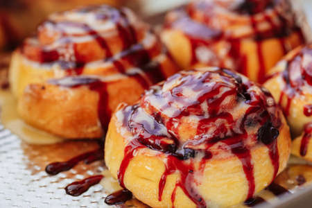 Freshly baked cinnabon buns with cream sauce on baking paperの写真素材