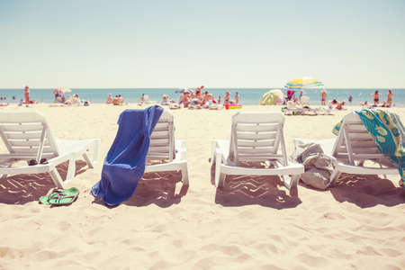 A row of three beach chairs overlooking the sea viewの写真素材