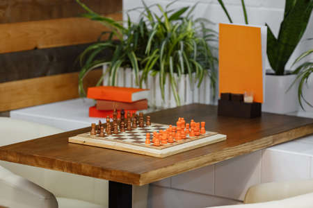 wooden chess on a table with books