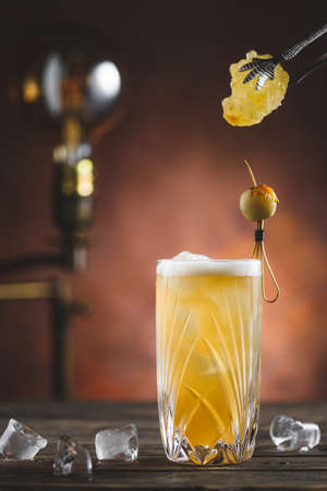 Cocktail on rustic wood background. Cold citrus alcohol beverage with tequila, blood juice and ginger beer, served with citrons and ice, copy spaceの写真素材