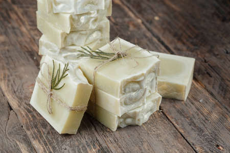 pieces of handmade soap laid out on a wooden background. Many pieces of soap are white. Close-up. Tied with twine, rustic styleの写真素材