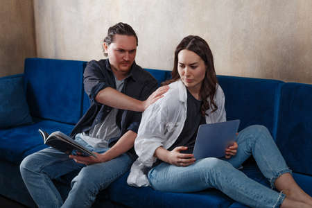 Angry, unhappy young couples, ignoring each other without looking at each other after a family fight or quarrel, frustrate thoughtful spouses by avoiding conversation, sitting silently on the couch, having troubled relationships. push each other awayの写真素材