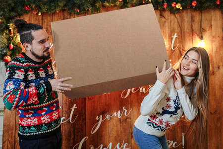 a guy and a girl carry a huge box home