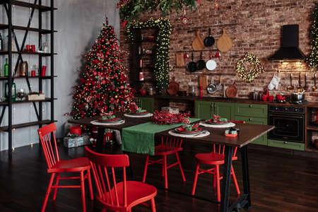 Christmas decorated kitchen interior with comfortable table; Christmas fir treeの写真素材