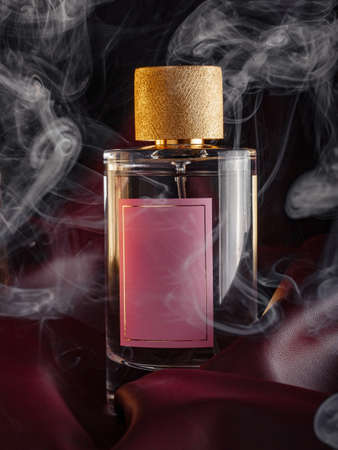 bottle of perfume on a dark maroon background with smokeの写真素材