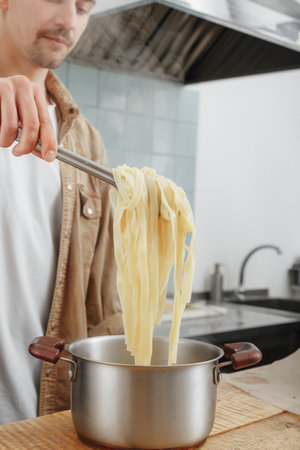 man makes handmade cheese pasta for lunchの写真素材