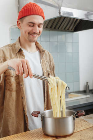man cooking cheese handmade pasta for lunchの写真素材