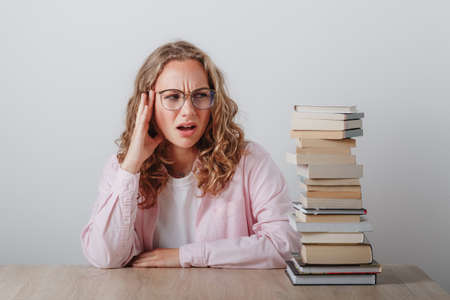 college girl with glasses has headache just thinking how much she has to learnの写真素材