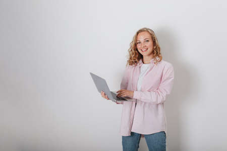A girl with curly hair on a white background holding a laptopの写真素材