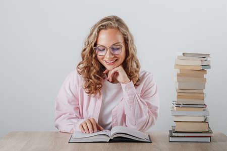 beautiful student smiles and reads a bookの写真素材