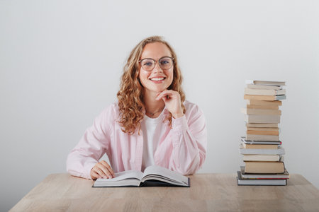 Girl in glasses and a large stack of booksの写真素材