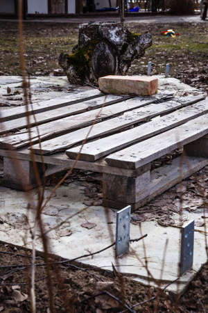 construction object started; wooden pallet and brick in a building site; old strain and wooden pallete on concrete floor; construction work.の写真素材