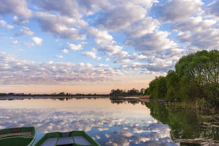lake landscape with sunset and sky, cloud reflection in water; shoreline with fishermen's footbridgeの写真素材