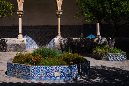 Flower beds are made in the courtyard of a historic building, the sides are made of decorative blue tiles, some damaged.の写真素材