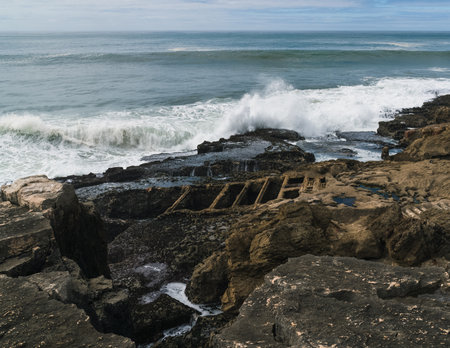 Atlantic Ocean waves whipping white foam against the rocky shore, Ericeira, Portugal.の写真素材