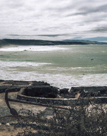 Natural landscape with the greenish-blue water surface of the Atlantic Ocean, a historic anchor in...