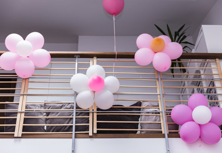 Flowers made from pink and white balloons to decorate the railing of the second floor of the house for a child's birthday party.の写真素材