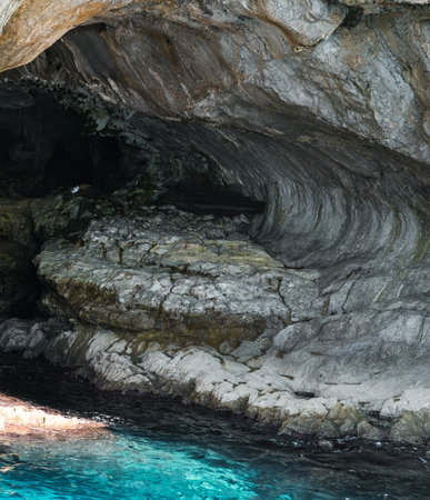 Capri, Italy - 04.29.2025: View of the interior of a cave in the cliff of the island of Capri; the light blue sea water near the cave is beautifully illuminated.の写真素材