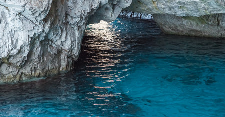 Capri, Italy - 04.29.2025: View of the interior of a cave in the cliff of the island of Capri; the light blue sea water near the cave is beautifully illuminated.の写真素材