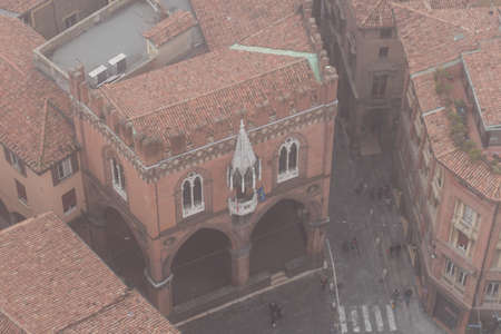 Typical street and buildings of Bologna. View from a narrow window with iron grid of Asinelli Tower. Emilia Romagna , Italy.の写真素材