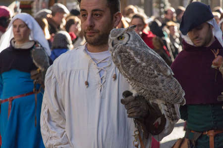 Italy, Florence - January 6 2017: the view of the man in medieval costume holding an owl at traditional parade of Epiphany Befana, medieval festival in Florence on 6 January 2017, Florence, Tuscany, Italy.のeditorial素材