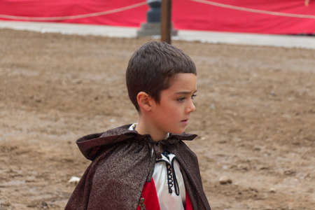 Italy, Brescia - October 01 2017: the view of a boy in medieval costume at traditional parade, celebrations of Caterina Cornaro is coming to Brescia, medieval festival in Piazza Loggia on October 01 2017, Lombardy, Italy.のeditorial素材
