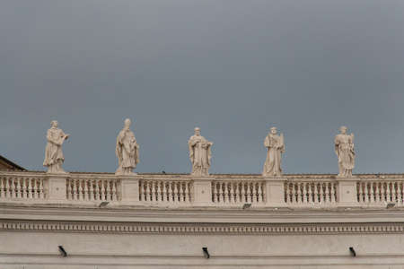 Italy, Vatican city - April 18 2017: the view of colonnade statues with rainy sky on background on...