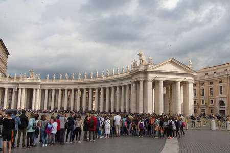 Italy, Vatican city - April 18 2017: the view of people and colonnade at Saint Peter's Square with...