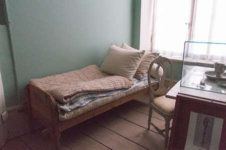 Mariefred, Sweden - April 20 2019: the view of a small room with a desk, a chair and a bed in Gripsholm Castle on April 20 2019 in Mariefred, Sweden.のeditorial素材