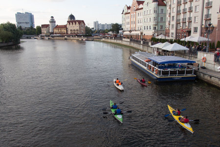 Kaliningrad, Russia - August 02 2019: the view of water activity on Pregolya river near The Fishing Village, lighthouse and Konigsberg New Synagogue on August 02 2019 in Kaliningrad, Russia.のeditorial素材