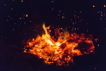 The view of a dying bonfire ready for snuffing on black background.
