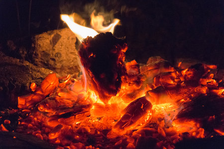 The view of a dying bonfire ready for snuffing on black background.の写真素材
