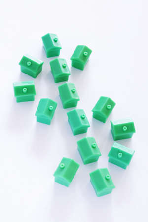 Dollar sign made from green model houses on white backgroundの写真素材
