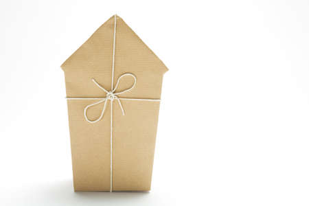 Studio Shot Of Model House Wrapped In Brown Paper And Tied With Stringの写真素材