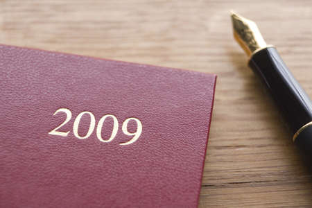 Red Leather 2009 Diary And Fountain Pen On Wooden Counterの写真素材