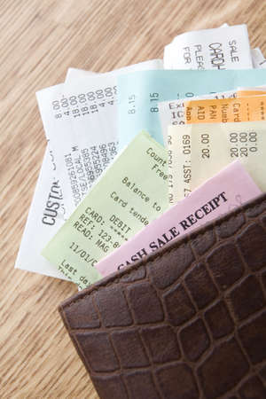 Brown Leather Wallet Filled With Receipts On Wooden Counterの写真素材
