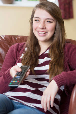Teenage Girl Relaxing And Watching TV At Home