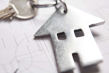 Keys To Home On Architects Plans With House Shaped Keyringの写真素材