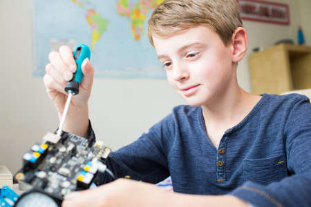 Boy Assembling Robotic Kit In Bedroomの写真素材